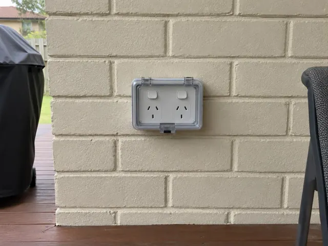 Outdoor double power point on a painted brick wall beside a timber deck in Booragul